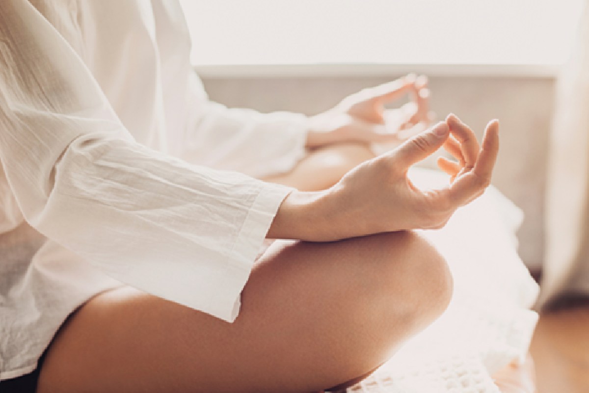 A woman meditating in her bedroom